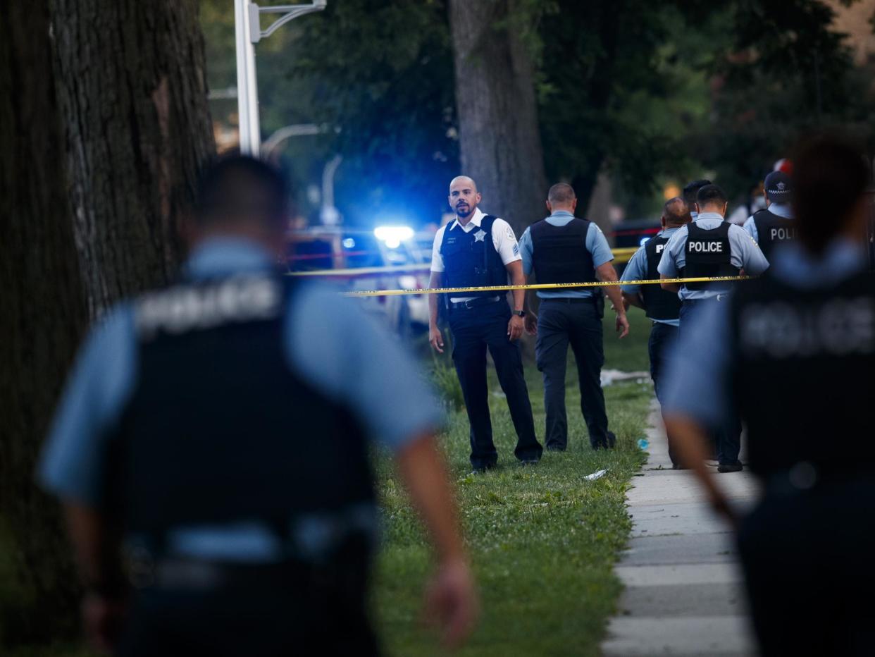 An officer investigates the scene of a deadly shooting where a 7-year-old girl and a man was fatally shot in Chicago on Sunday: (Chicago Tribune)