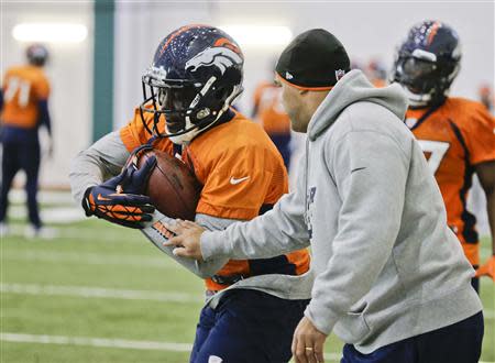 Denver Broncos running back Knowshon Moreno (L) runs a drill as an assistant tries to strip the ball from him during their practice session for the Super Bowl at the New York Jets Training Center in Florham Park, New Jersey January 30, 2014. REUTERS/Ray Stubblebine