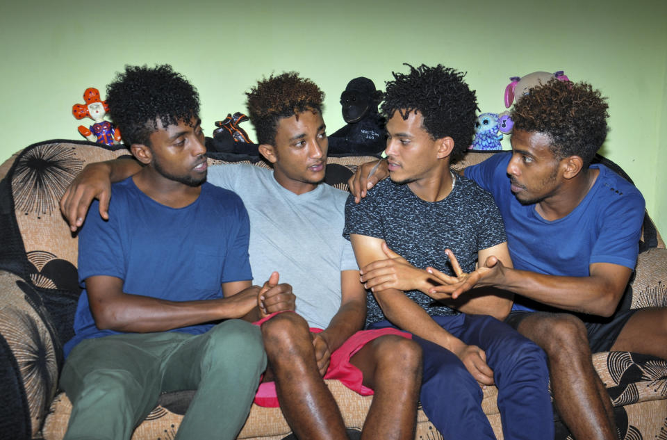 In this photo taken on Thursday, Oct. 10, 2019, from left, Eritrean under-20 soccer players Hermon Fessehaye Yohannes, Simon Asmelash Mekonen, Hanibal Girmay Tekle, and Mewael Tesfai Yosief talk together in a house where they are staying in Uganda. Four young players with Eritrea's national under-20 soccer team have defected during a tournament in Uganda, the latest players to leave one of the world's most tightly controlled regimes. (AP Photo)