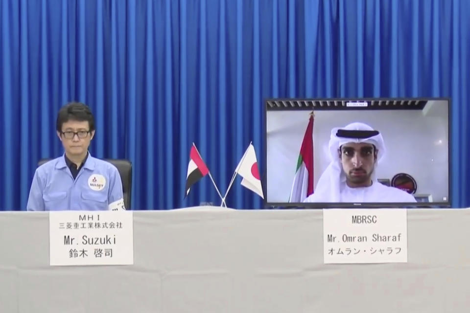 In this image made from video released by Mitsubishi Heavy Industries, project manager Omran Sharaf, left, and and Keiji Suzuki of Japan's Mitsubishi Heavy Industries, attend a pre-launch video briefing of a Mars orbiter, Monday, July 13, 2020. The United Arab Emirates is up first with the Martian orbiter set to launch from Japan on Wednesday, July 15. The liftoff of the Mars orbiter named Amal, or Hope, from Japan marked the start of a rush to fly to Earth's neighbor. (Mitsubishi Heavy Industries via AP)