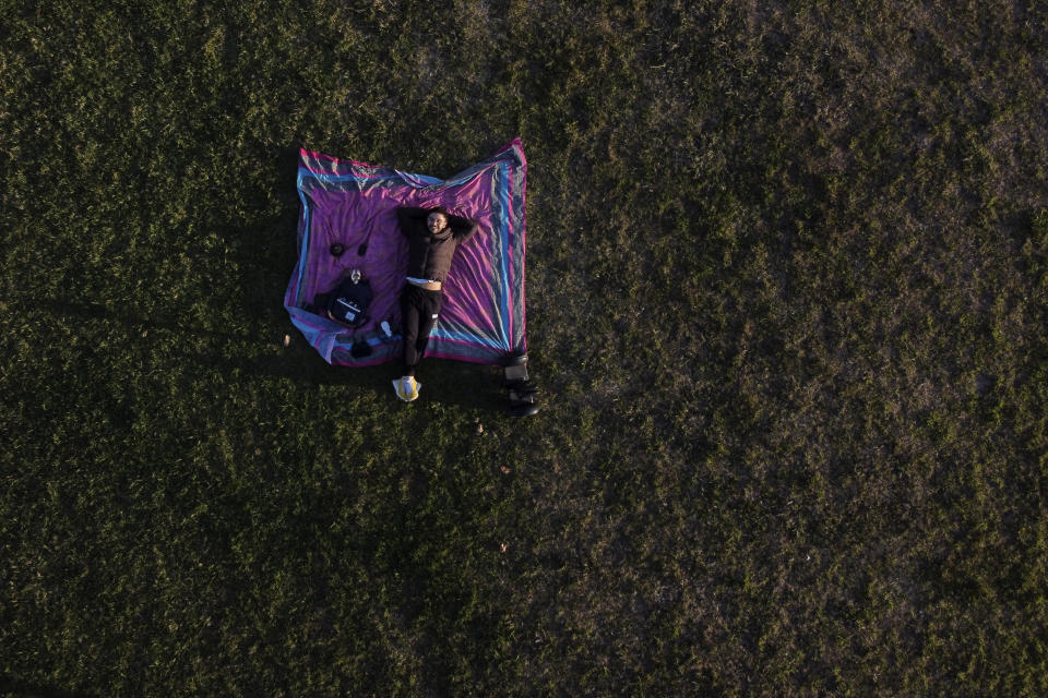 Un hombre descansa en un parque en medio de la pandemia de COVID-19 en Buenos Aires, Argentina, el domingo 6 de junio de 2021. (AP Foto/Natacha Pisarenko)