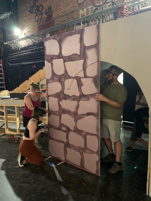 Mindy Abate and her daughter Mills Schaefer (Belle) attach the stone work and Set Designer, Casey Blanton, uses a hot knife to cut out an archway on the set of Disney’s “Beauty and the Beast” at Leon High School.