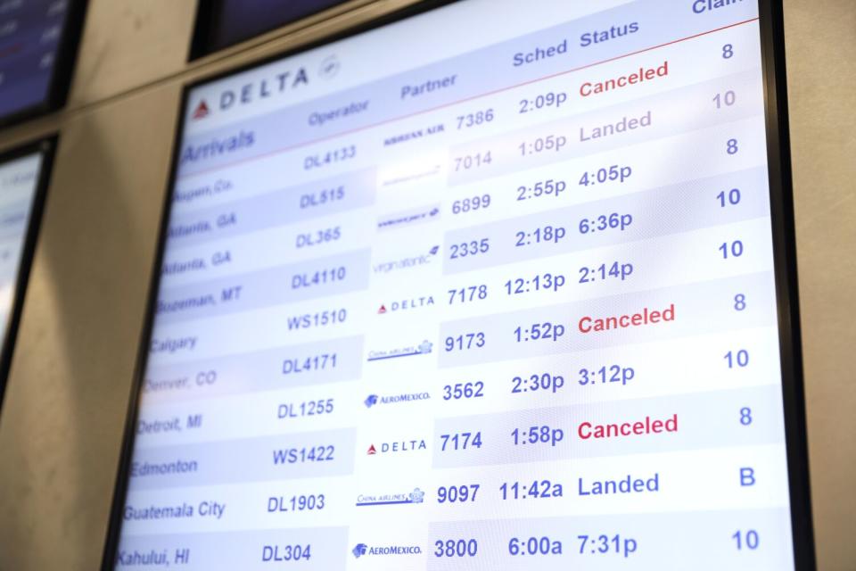 A few canceled flights show up on the departure board in the Delta terminal at LAX on Dec. 27.