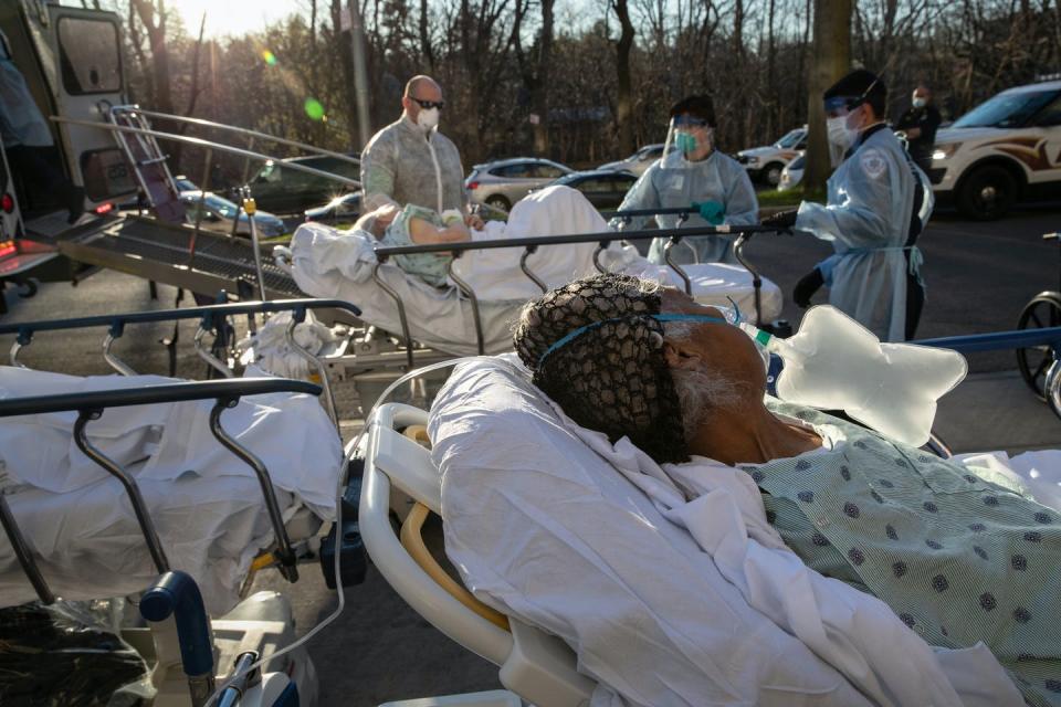 Several patients on gurneys outside a hospital.