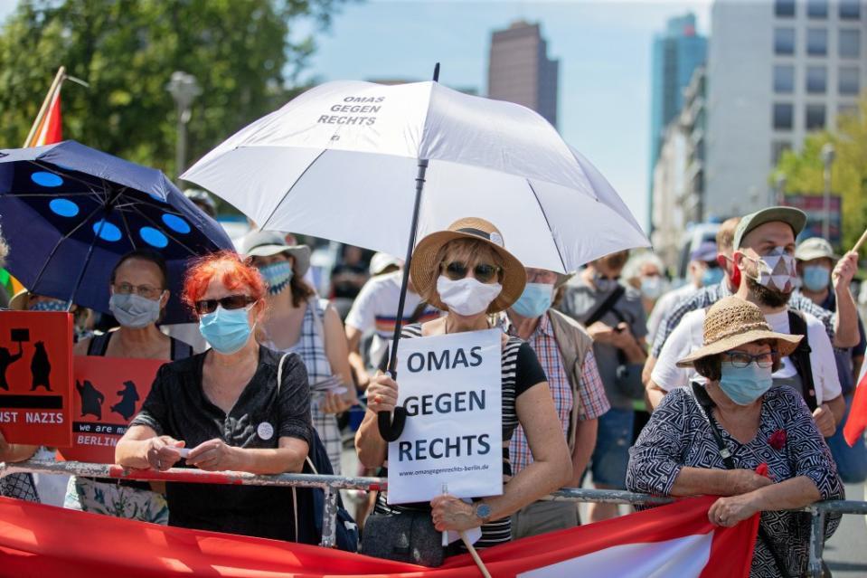 Ein Plakat ·Omas gegen rechts· hält eine Frau mit Mund-Nasen-Schutz bei einer Gegendemonstration zur Demonstration gegen die Corona-Beschränkungen auf der Leipziger Straße.<span class="copyright">Christoph Soeder / dpa</span>