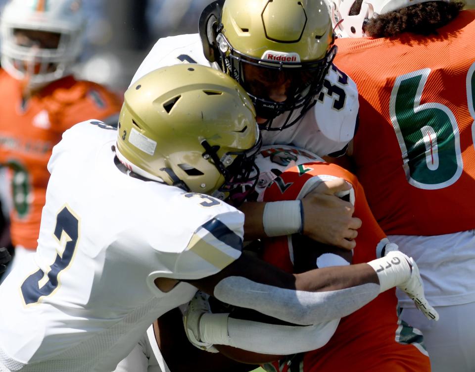 Hoban's Rickey Williams and Eli Lee tackle Frederick Douglass' Kenoxie Allen in the first quarter, Saturday, Aug. 19, 2023, in Canton.