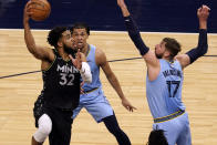 Minnesota Timberwolves' Karl-Anthony Towns (32) shoots as Memphis Grizzlies' Jonas Valanciunas (17) defends in the first half of an NBA basketball game Wednesday, May 5, 2021, in Minneapolis. (AP Photo/Jim Mone)