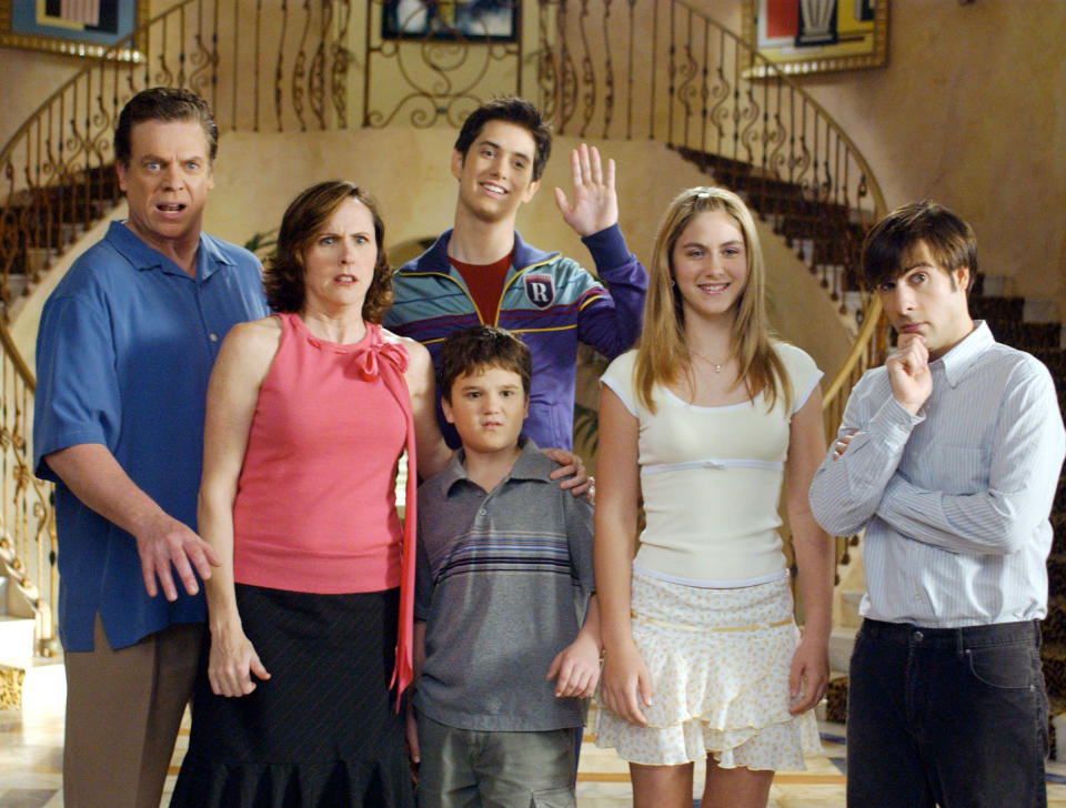 Chris McDonald, Molly Shannon, Jake Sandvig, Bret Loehr, Caitlin Wachs, and Jason Schwartzman stand in the foyer of a mansion