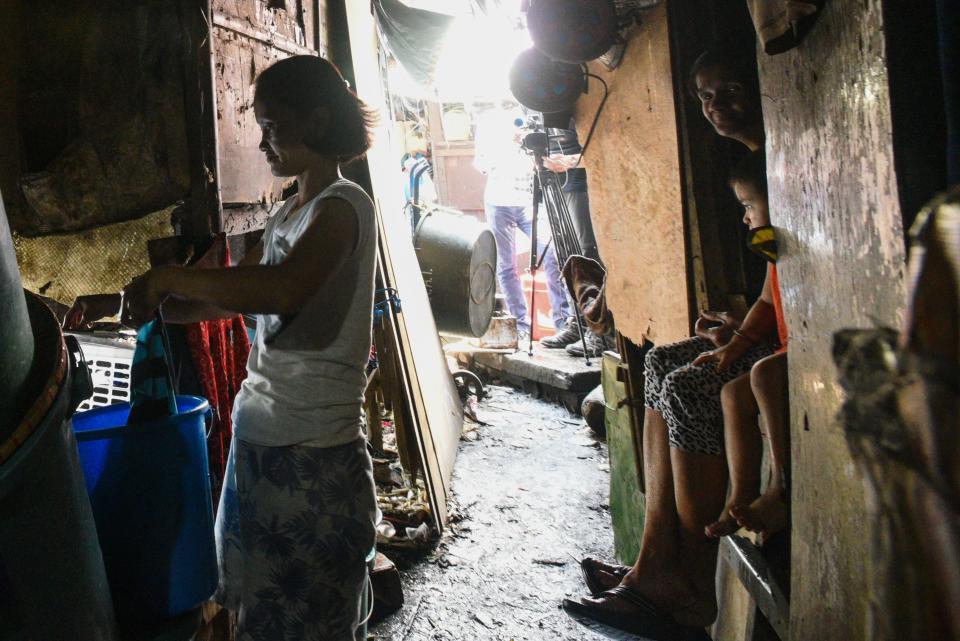 TOPSHOT - This photo taken on March 18, 2020 shows a mother washing her laundry outside her home along the river in Manila. - Asian nations have imposed increasingly heavy measures to fight the outbreak of the COVID-19 coronavirus, the Philippines has ordered half its population of some 110 million to stay home. (Photo by Maria TAN / AFP) / TO GO WITH Health-virus-Philippines-poverty,FOCUS by Joshua Melvin and Ron Lopez (Photo by MARIA TAN/AFP via Getty Images)