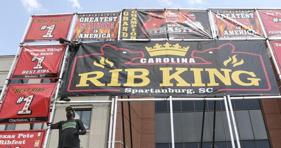 Solomon Williams, owner of Carolina Rib King of Spartanburg, S.C., sets up his stand with crew member Quan Pruitt at the 2019 Rib, White and Blue Festival in Akron.