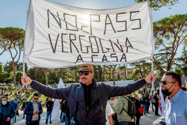 ROME, ITALY - OCTOBER 15: A protester holds a sign during a demonstration organized by No Green Pass, No Vax and far-right movements against the Green Pass, following the new decree outlined by Italian Government, at Circo Massimo on October 15, 2021 in Rome, Italy.  As of October 15, the 23 million civil servants and employees in Italy must present proof of vaccination or a negative Covid-19 test to work. A measure that could paralyze certain sectors of the economy. (Photo by Stefano Montesi - Corbis/Corbis via Getty Images) (Photo: Stefano Montesi - Corbis via Getty Images)