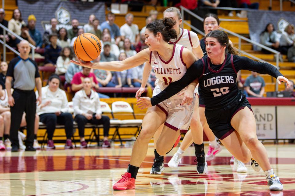 Willamette's Kaitlin Imai (11) and Puget Sound's Kennedy Brown (20) battle for the rebound during the NWC semifinal game at Cone Field House on Friday, Feb. 23, 2024, in Salem, Ore.