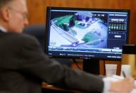 Charles Rankin (L), defense attorney for former New England Patriots football player Aaron Hernandez, uses a pen as June 17, 2013 surveillance video from Hernandez's home is displayed on a monitor during Hernandez's murder trial in Fall River, Massachusetts March 26, 2015. REUTERS/Steven Senne/Pool