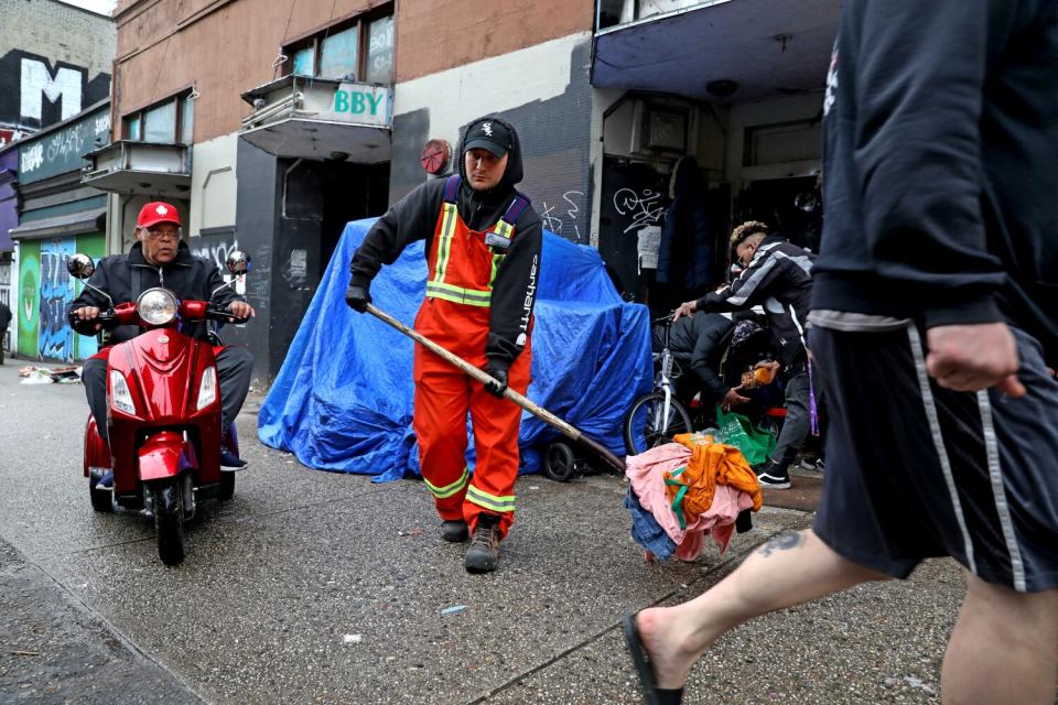 A worker cleans a sidewalk