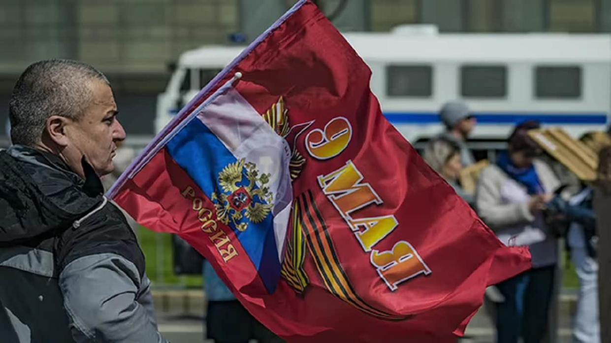 A man with flag, reads 9 May, Russia. Stock photo: Getty Images