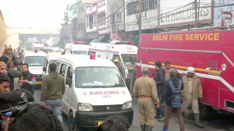 Video grab of ambulences and a firefighting vehicle at the scene of a deadly fire that swept through a factory where laborers were sleeping, in New Delhi