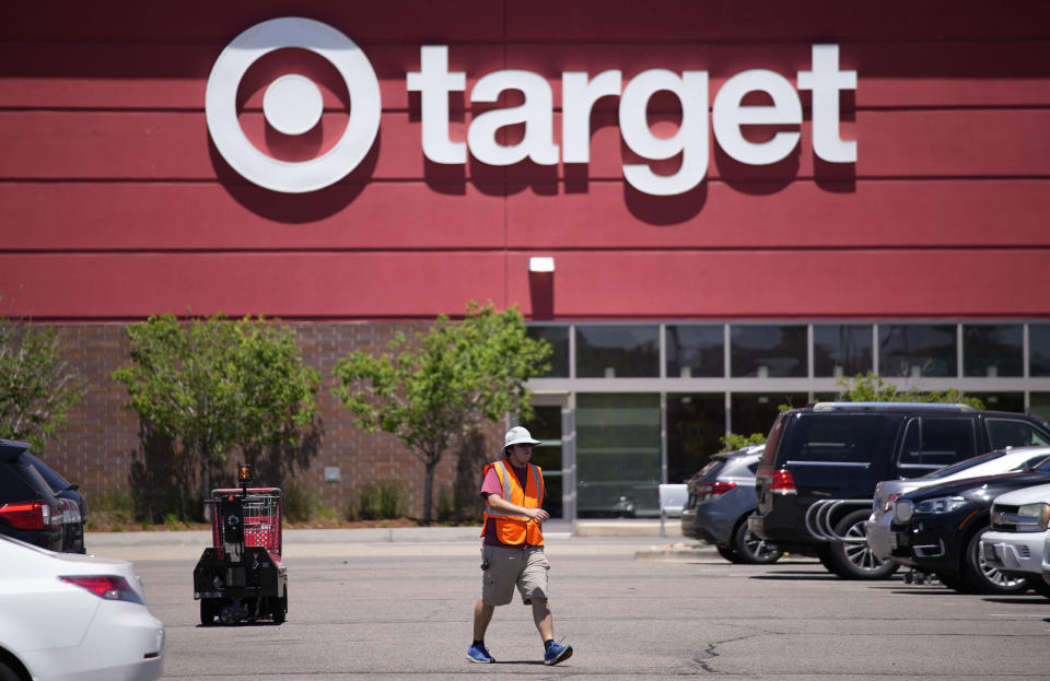 FILE - A worker collects shopping carts in the parking lot of a Target store on June 9, 2021, in Highlands Ranch, Colo. Target is removing certain items from its stores and making other changes to its LGBTQ merchandise nationwide ahead of Pride month, after an intense backlash from some customers including violent confrontations with its workers. (AP Photo/David Zalubowski, File)