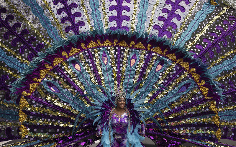 A dancer in costume participates in the West Indian Day Parade