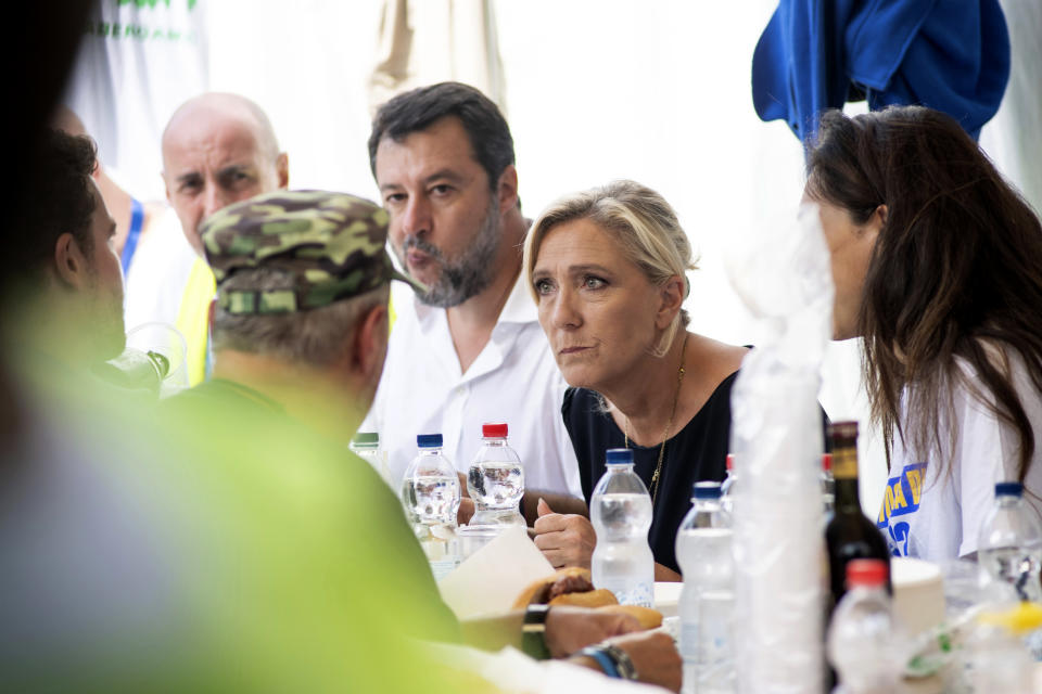 French right-wing leader Marine Le Pen, center, listens as she is flanked by Italian Vice Premier Matteo Salvini, head of the populist, right-wing League, left, at a luncheon on the occasion of an annual League (Lega) party rally, in Pontida, northern Italy, Sunday, Sept. 17, 2023. (Claudio Furlan/LaPresse via AP)