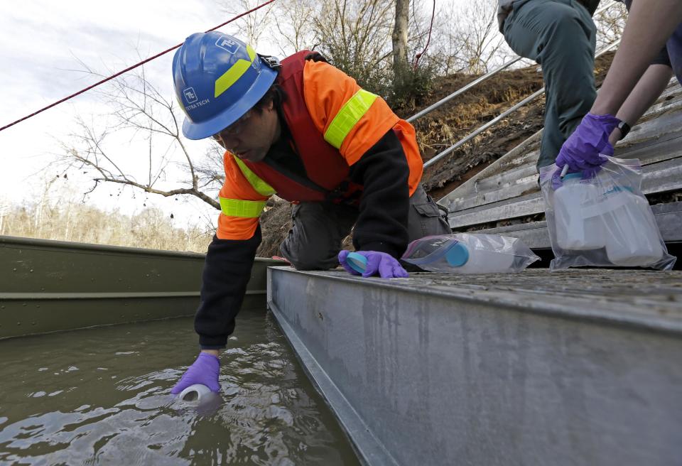 Didi Fung, a contractor for the Environmental Protection Agency, collects water samples from the Dan River as state and federal environmental officials continued their investigations of a spill of coal ash into the Dan River in Eden, N.C., Wednesday, Feb. 5, 2014. Duke Energy estimates that up to 82,000 tons of ash has been released from a break in a 48-inch storm water pipe at the Dan River Power Plant on Sunday. (AP Photo/Gerry Broome)