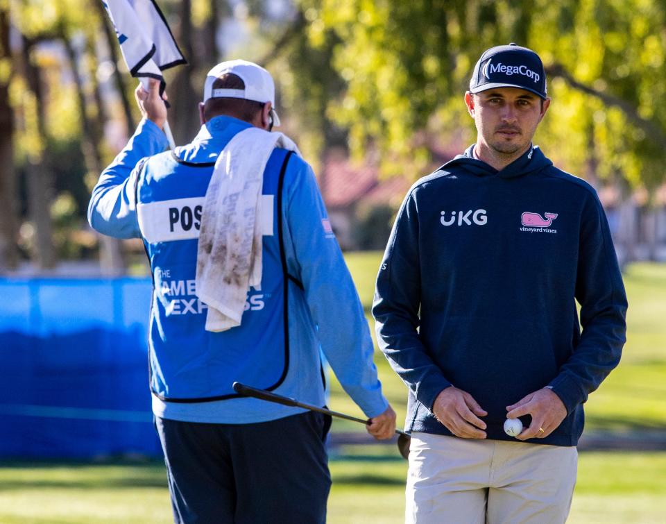 J.T. Poston picks up his ball after finishing putting on the 11th green during round three of The American Express at La Quinta Country Club in La Quinta, Calif., Saturday, Jan. 21, 2023. 