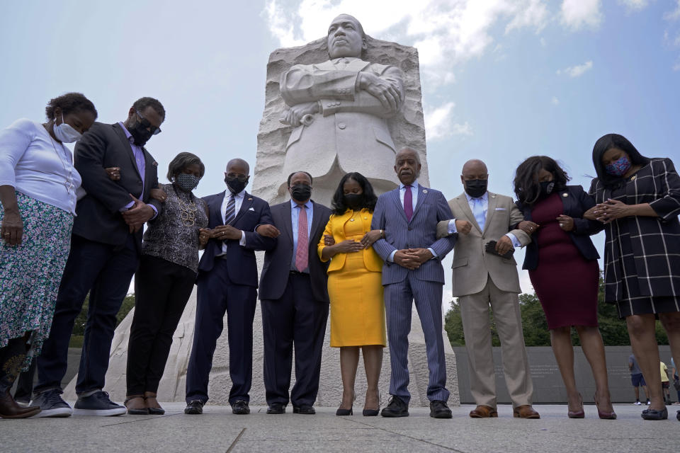 Martin Luther King III, center, with his wife Arndrea Waters King, in yellow, and Rev. Al Sharpton, right of Mrs. King, pray with members of the Texas State Democratic Delegation at the Martin Luther King, Jr. Memorial, Wednesday July 28, 2021, in Washington. From left are, Rep. Sheryl Cole, Rep. Jarvis Johnson, Rep. Rhetta Bowers, Rep. Ron Reynolds, Martin Luther King III, Arndrea Waters King, Rev. Al Sharpton, Rep. Carl Sherman, Rep. Jasmine Crockett, and Rep. Shawn Thierry. (AP Photo/Jacquelyn Martin)