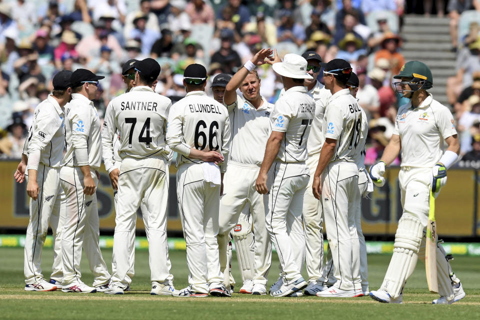 New Zealand players celebrate the wicket of Australia's Tim Paine, right, during play in their cricket test match in Melbourne, Australia, Friday, Dec. 27, 2019. (AP Photo/Andy Brownbill)