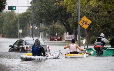 A group of civilian volunteer rescuers assemble whatever floating vessels they have and take to the flooded streets of west Houston - Credit:  James Breeden / Telegraph