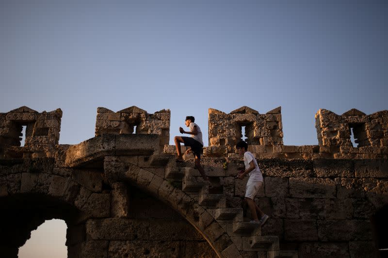 Two boys climb the walls of the castle in the Old Town of Rhodes, following the coronavirus disease (COVID-19) outbreak, on the island of Rhodes