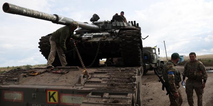 A Russian T-72 tank is loaded on a truck by Ukrainian soldiers outside the town of Izyum on September 24, 2022.