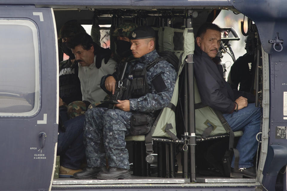 Joaquín "El Chapo" Guzmán (centro con camisa blanca) sentado en un helicóptero de la Policía Federal en un hangar de la Marina en la Ciudad de México, el sábado 22 de febrero de 2014. El narco más buscado del mundo llegó al aeropuerto de la Ciudad de México tras su arresto a primeras horas del sábado y era llevado directamente a prisión, dijo Jesús Murillo Karam, procurador general de la república. Foto (AP/Eduardo Verdugo)