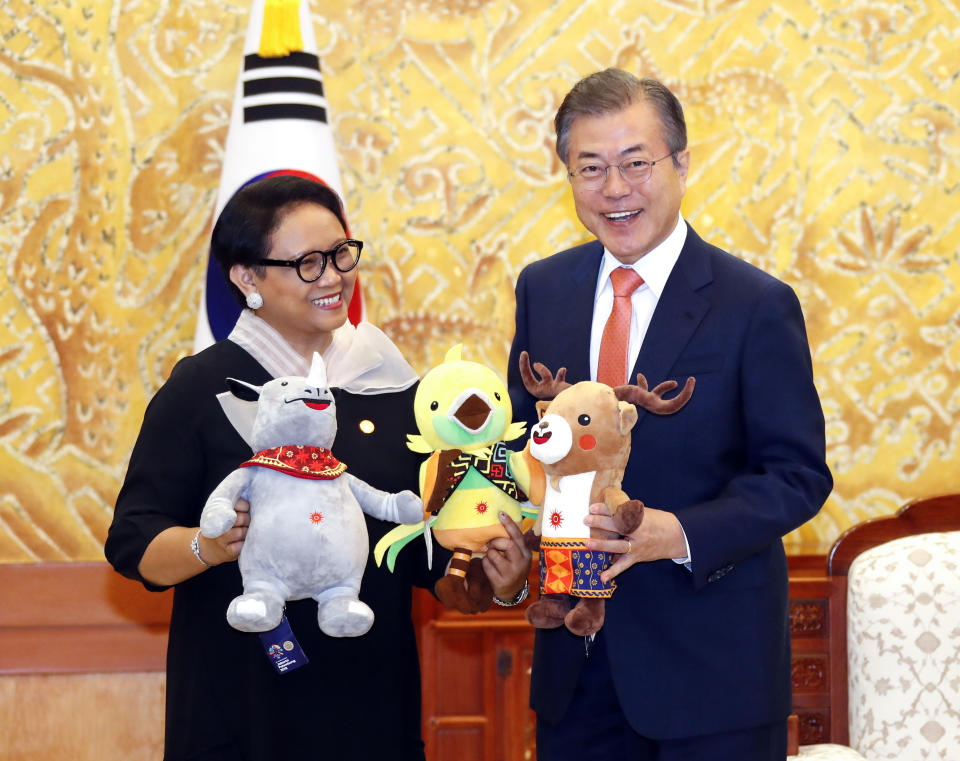 In this July 27, 2018, photo, South Korean President Moon Jae-in, right, and Indonesian Foreign Minister Retno Marsudi hold the mascots of the 2018 Asian Games, from left to right, Kaka, Bhin Bhin and Atung during their meeting at the presidential Blue House in Seoul, South Korea. The war-separated rivals will take their reconciliation steps to the Asian Games in Jakarta and Palembang, Indonesia, where they will jointly march in the opening ceremony and field combined teams in basketball, rowing and canoeing. (Bae Jae-man/Yonhap via AP)