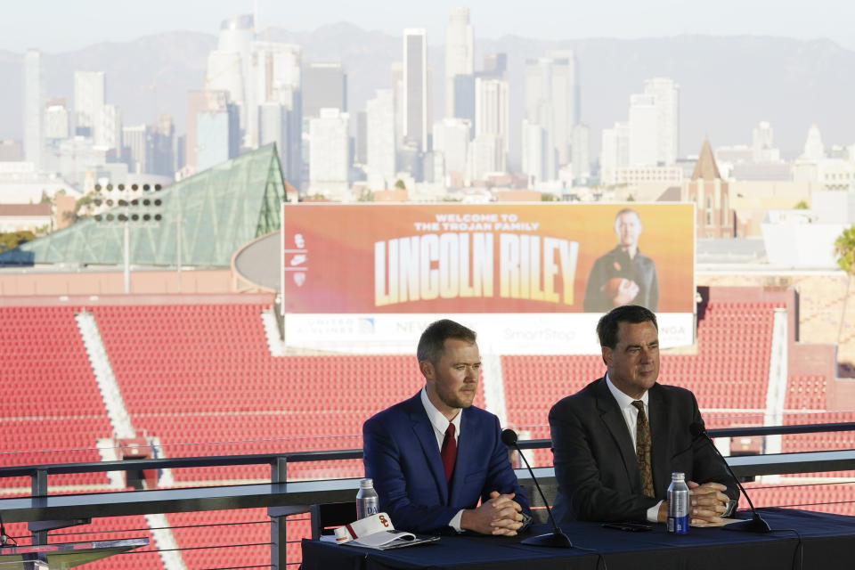 Lincoln Riley, left, the new head football coach of the University of Southern California, and Athletic Director Mike Bohn, right, answer questions during a ceremony in Los Angeles, Monday, Nov. 29, 2021. (AP Photo/Ashley Landis)