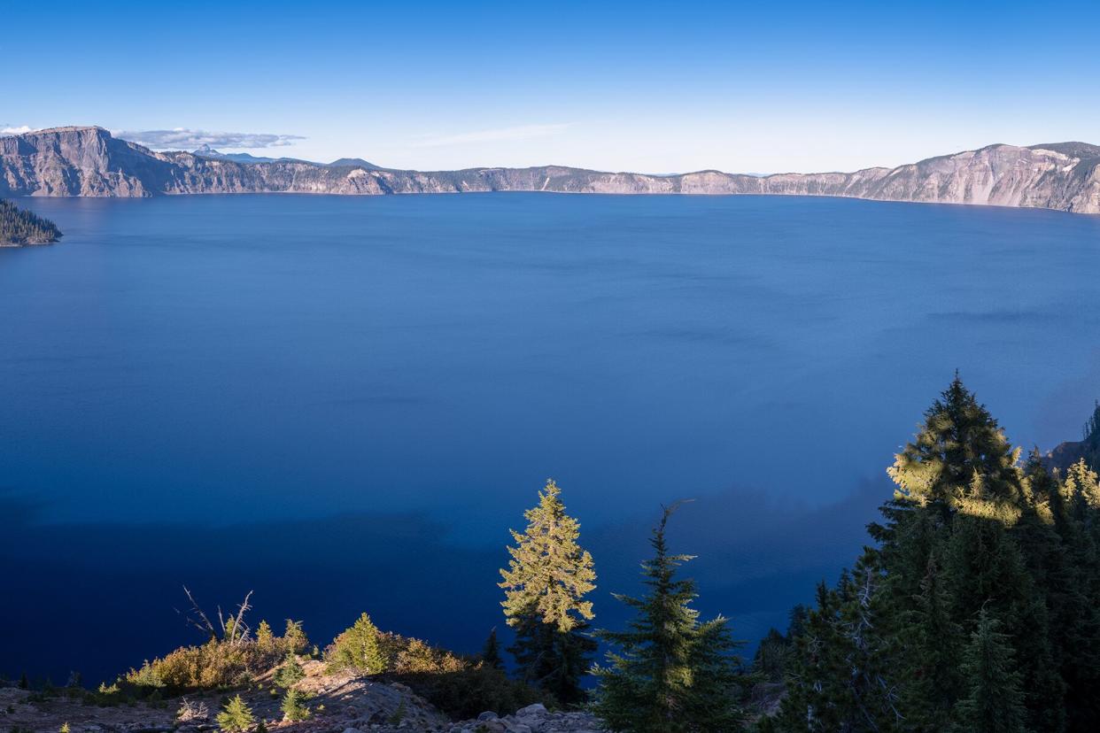 A wide panorama view of blue water in Crater Lake , Oregon. Shot from Rim Village in the afternoon.