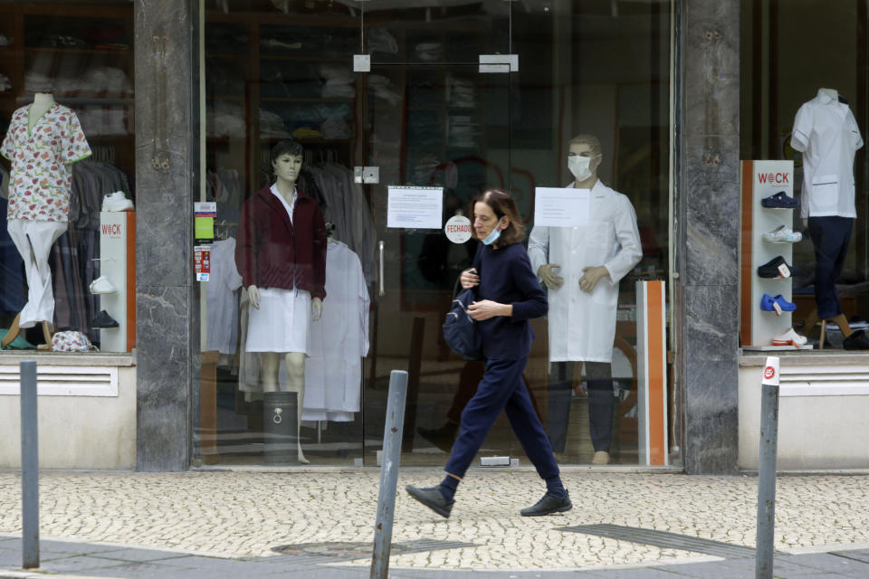 A person walks past a closed shop selling medical clothing in Lisbon, Wednesday, Jan. 27, 2021. Portugal has had the world's worst rate of new daily cases and deaths per 100,000 population for the past week, according to a tally by Johns Hopkins University. (AP Photo/Armando Franca)