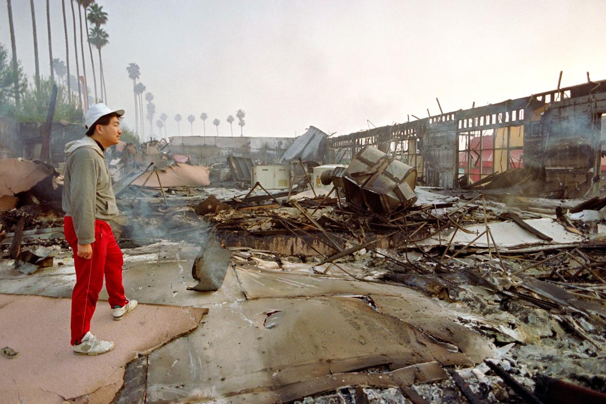A merchant looks over the remains of a retail center in Los Angeles