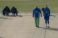 Pakistan's skipper Babar Azam, right, and coach Saqlain Mushtaq inspect the pitch preparing for the 1st test cricket match between Pakistan and England, in Rawalpindi, Pakistan, Wednesday, Nov. 30, 2022. (AP Photo/Anjum Naveed)