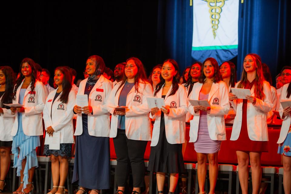 First-year medical students recite their class-composed version of the ancient Oath of Hippocrates during Friday's White Coat Ceremony held by the Texas Tech University Health Sciences Center at the Buddy Holly Hall of Performing Arts and Sciences.