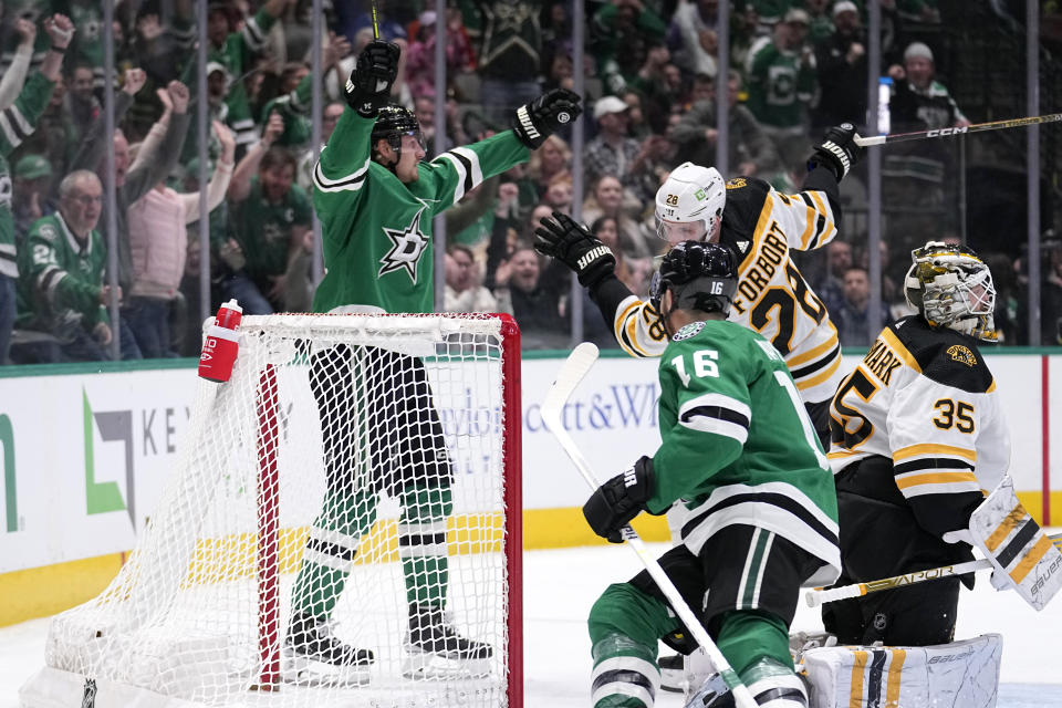 Dallas Stars center Roope Hintz, left rear, celebrates after scoring against Boston Bruins' Linus Ullmark (35) on an assist from Joe Pavelski (16) as Derek Forbort (28) helps defend on the play in the first period of an NHL hockey game, Tuesday, Feb. 14, 2023, in Dallas. (AP Photo/Tony Gutierrez)