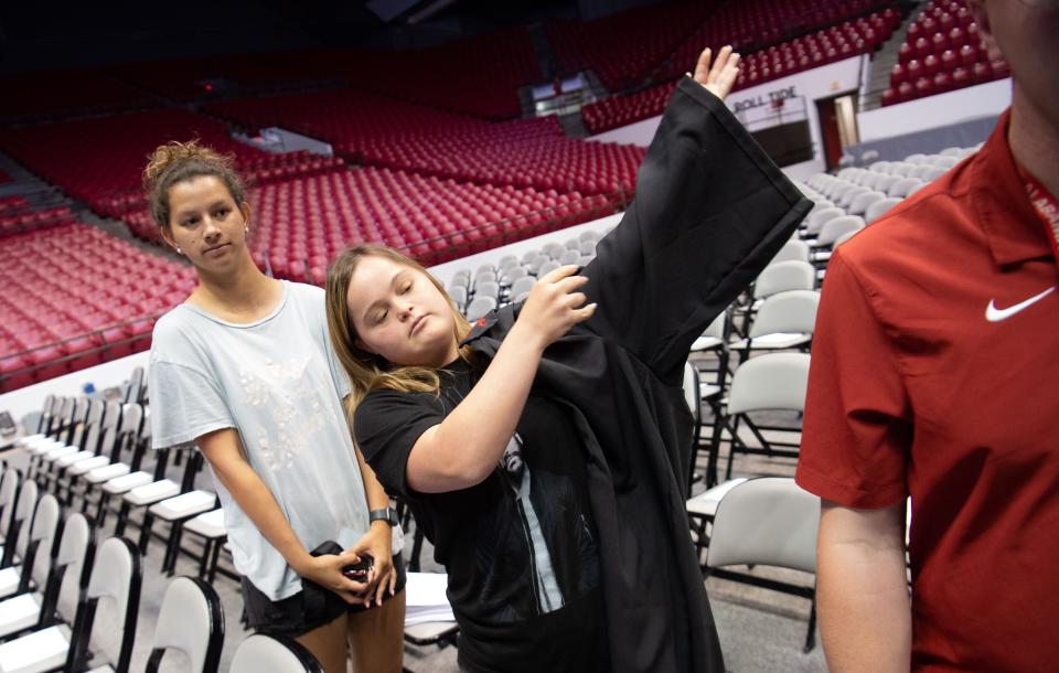 May 5, 2022; Tuscaloosa, AL, USA; The Crossing Points Program at the University of Alabama rehearsed for the program's first ever graduation Thursday at Coleman Coliseum. Maeghan DeLoach dons a robe as she waits during practice to take the stage. Mandatory Credit: Gary Cosby Jr.-The Tuscaloosa News
