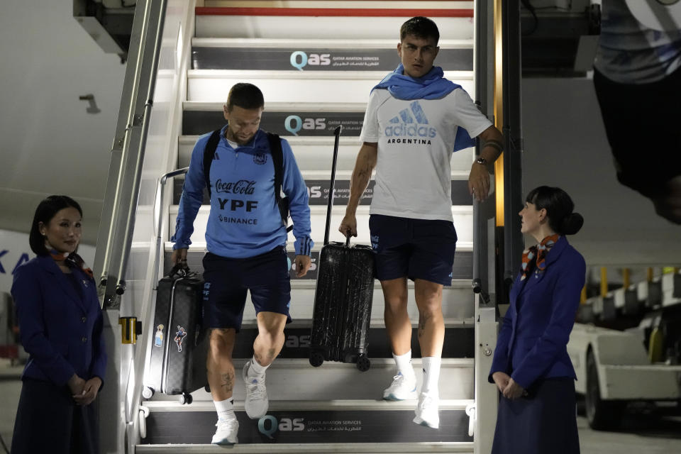 Paulo Dybala, right, of Argentina's national soccer team arrives with teammates at Hamad International airport in Doha, Qatar, Thursday, Nov. 17, 2022 ahead of the upcoming World Cup. Argentina will play the first match in the World Cup against Saudi Arabia on Nov. 22. (AP Photo/Hassan Ammar)