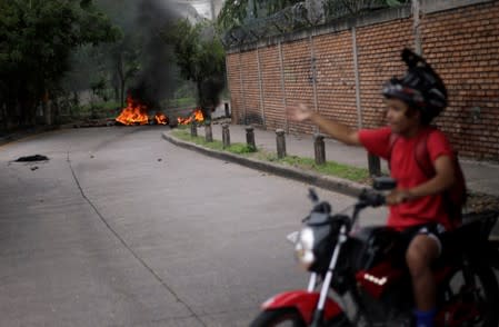 A motorcyclist passes near a barricade during a protest against the government of Honduras' President Juan Orlando Hernandez, in Tegucigalpa