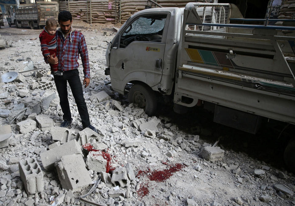 A man&nbsp;and child look at the rubble of damaged buildings after an airstrike on the rebel-held city of Douma on Nov. 2, 2017. (Photo: Bassam Khabieh / Reuters)