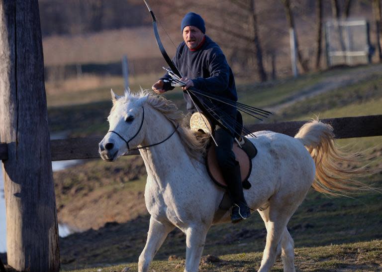 Lajos Kassai, a master horseback archer in Hungary, prepares his shot at the 'Valley' in Kaposmero village on March 7, 2015