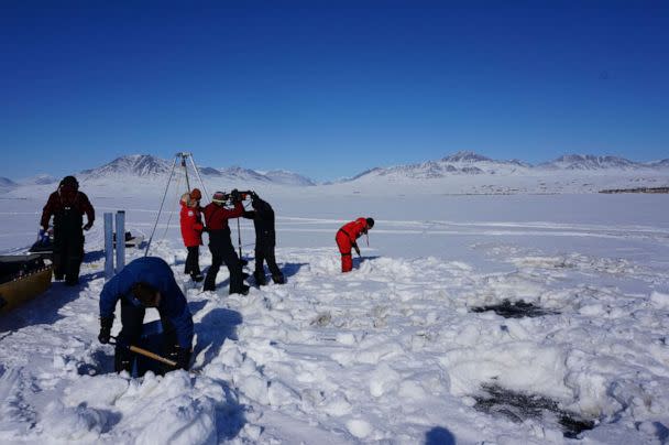 PHOTO: This handout picture taken on May 29, 2017, shows researchers drilling holes to collect sediment at the Lake Hazen in Nunavut, to investigate how climate change might increase the risk of 'viral spillover.  (Graham Colby/Graham COLBY/AFP via Getty Image)