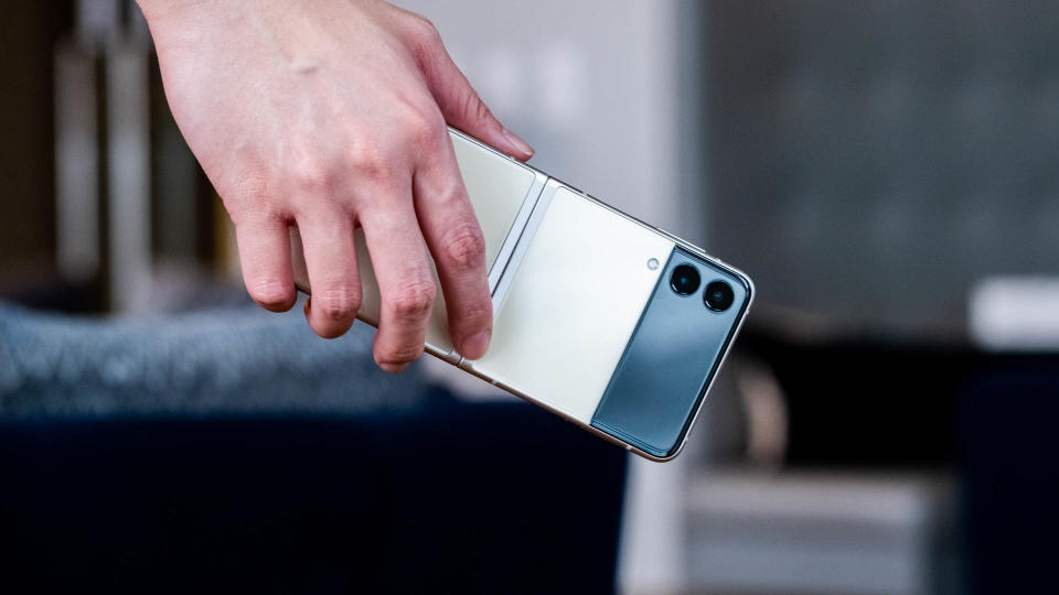 The Samsung Galaxy Z Flip 3 unfolded in someone's hand, with its rear facing the camera