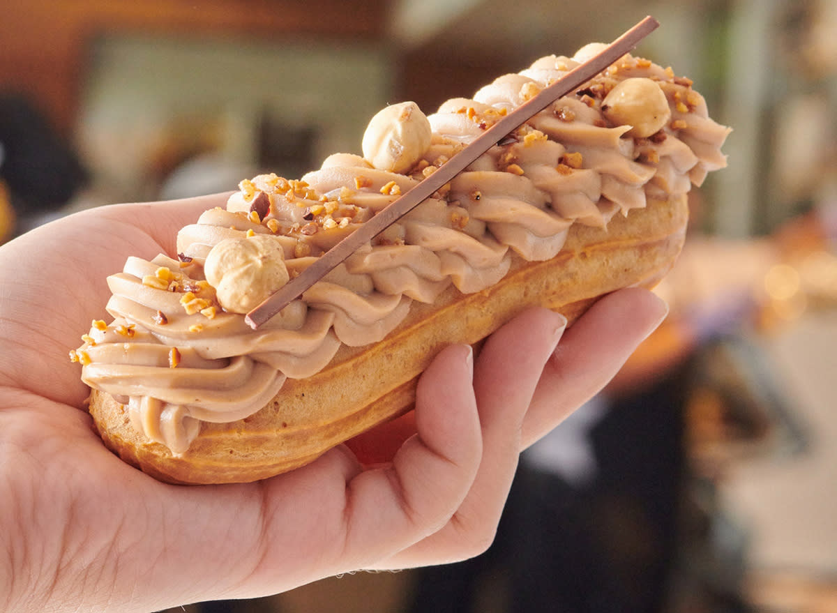 A chocolate hazelnut Éclair held aloft at Porto's Bakery