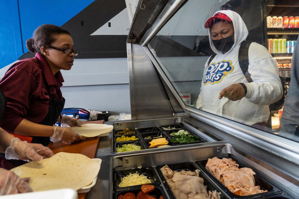 Hamtramck High School student Nautica Hankins, right, selects toppings for a panini to be made during lunch at Hamtramck High School in Hamtramck on April 7, 2022.