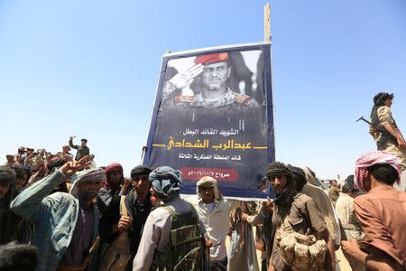Pro-government fighters gather around a poster of Major-General Abdel-Rab al-Shadadi, a top general in forces loyal to Yemeni President Abd-Rabbu Mansour Hadi's government killed in fighting with Iran-aligned Houthi troops, during his funeral in Marib city, Yemen October 9, 2016. The poster reads: "The hero martyr Abdel-Rab al-Shadadi, the commander of the Third Military Region". REUTERS/Ali Owidha