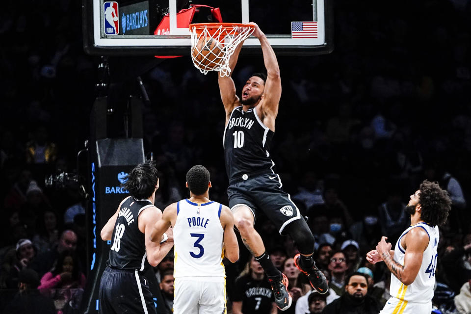 Brooklyn Nets' Ben Simmons (10) dunks the ball in front of Golden State Warriors' Jordan Poole (3) and Anthony Lamb (40) during the first half of an NBA basketball game Wednesday, Dec. 21, 2022 in New York. (AP Photo/Frank Franklin II)